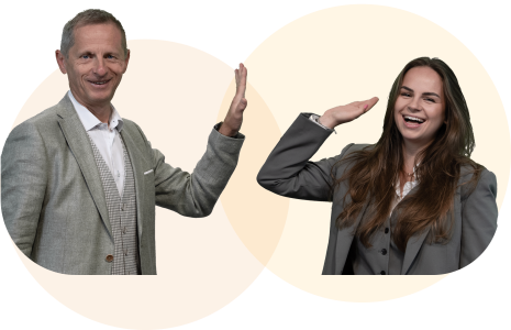 Geschäftsführer und Nachfolgerin geben sich ein High-Five als Symbol für erfolgreiche Unternehmensnachfolge.
